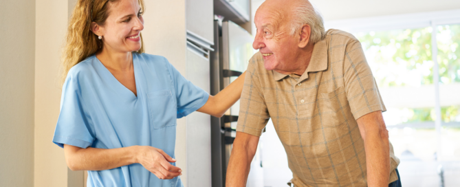Caregiver providing senior home care services smiling at senior man using a walker